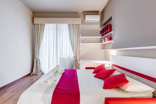 a bedroom with a bed with red pillows and a window at Exclusive Apartment in Eur Lake in Rome