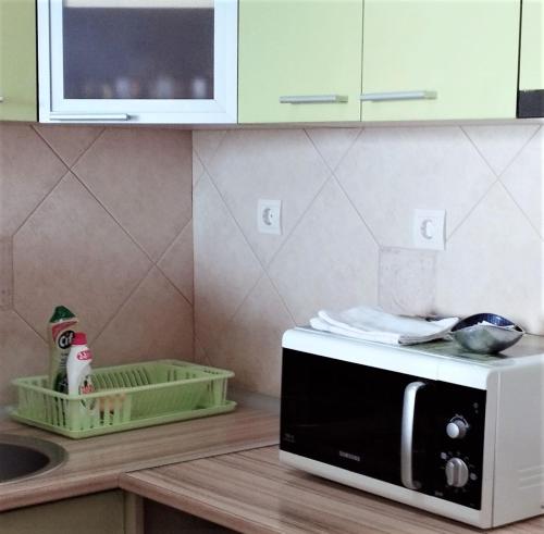 a kitchen counter with a microwave and a sink at Apartment Vukica with free parking in Petrovac na Moru
