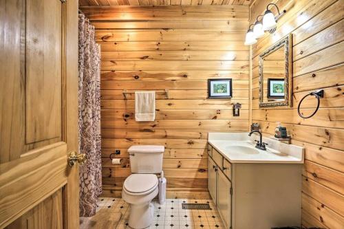 ein Badezimmer mit einem WC, einem Waschbecken und einem Spiegel in der Unterkunft Smoky's Lakeside Den in Sevierville