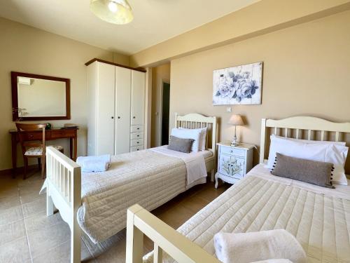 a bedroom with two beds and a mirror at Villa Marianna in Lourdhata