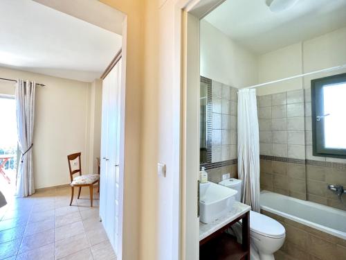 een badkamer met een wastafel, een toilet en een bad bij Villa Marianna in Lourdhata