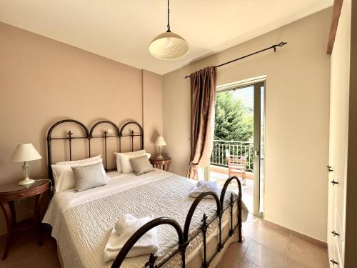 a bedroom with a large bed and a balcony at Villa Marianna in Lourdhata