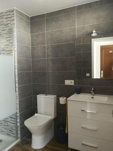 a bathroom with a toilet and a sink and a mirror at Comodoro Los Cristianos 301A in Los Cristianos