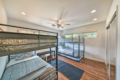 a room with three bunk beds and a ceiling fan at Luxury Home with Pool on San Jacinto Riverfront! in Houston