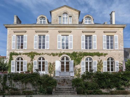 豐特奈勒孔特的住宿－Chambre d'hotes La maison de Maître，一间大型房屋,设有白色窗户和常春藤