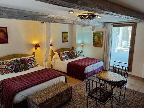 a hotel room with two beds and a window at Mas Peu Del Causse in Thuir