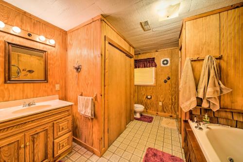 La salle de bains en bois est pourvue d'une baignoire, de toilettes et d'un lavabo. dans l'établissement The Burgundy Cabin Iowa Retreat Pond and Fire Pit, à Spragueville
