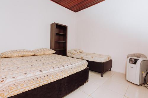 a bedroom with two twin beds and a heater at Casa c churrasq em Monte Castelo, Campo Grande-MS in Campo Grande
