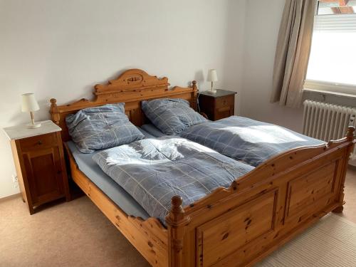 1 dormitorio con 1 cama de madera con 2 almohadas en Ferienwohnung zur Alten Schmiede, en Lenzkirch