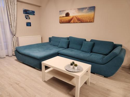 a living room with a blue couch and a table at Airport Apartment Otopeni in Otopeni