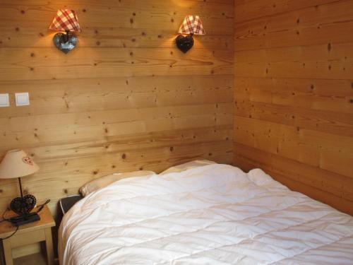 - une chambre avec un lit et deux lumières sur le mur dans l'établissement Appartement cosy au cœur de la station, départ skis aux pieds, Wi-Fi, proximité commerces - FR-1-634-63, à Avoriaz