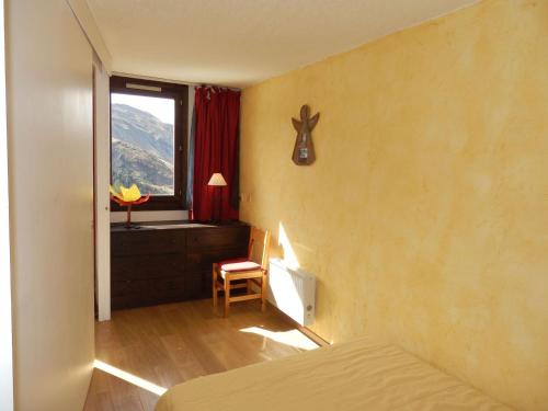 une chambre avec un lit, une fenêtre et une chaise dans l'établissement Appartement 2P 4 pers - Sud, Balcon, Internet, Animaux refusés - FR-1-634-53, à Avoriaz
