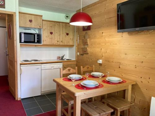 - une cuisine avec une table en bois, des assiettes et des verres à vin dans l'établissement Confortable Studio Cabine Montagne, Balcon Nord, Skis aux Pieds, Proche Centre Morzine - FR-1-634-68, à Avoriaz