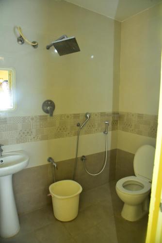 ein Bad mit einem WC, einem Waschbecken und einer Dusche in der Unterkunft SAI SADHAN RESIDENCY in Chittoor