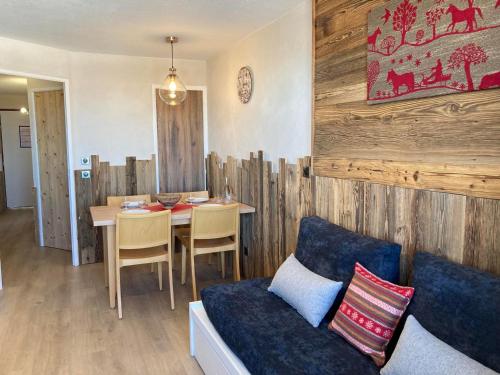 un salon avec une table et un canapé bleu dans l'établissement Appartement rénové 2P 4 pers, balcon, départ skis aux pieds - FR-1-634-76, à Morzine
