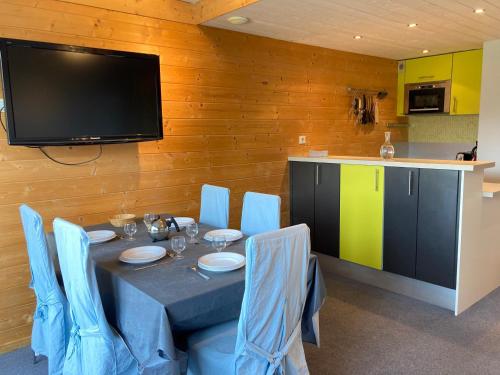 d'une salle à manger avec une table, des chaises et une télévision. dans l'établissement Agréable duplex 3 pièces, centre station, balcon sud, 5 pers. - FR-1-634-64, à Avoriaz