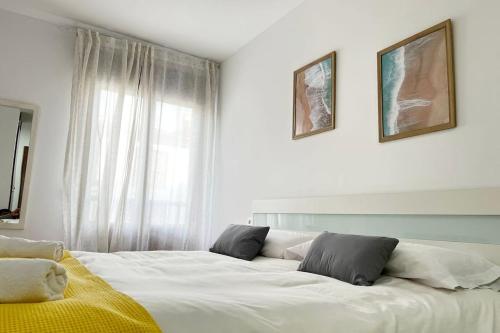 a bedroom with a large white bed with two pillows at Ayamonte Vista Esuri Golf - 12 min to Isla Canela in Huelva