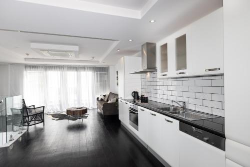 a kitchen with white appliances and a living room at Mount Views in Mount Maunganui
