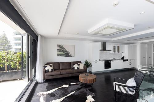 a living room with a couch and a table at Mount Views in Mount Maunganui