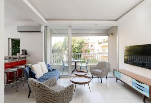 a living room with a couch and chairs and a table at Fragrant Flower by HolyGuest in Tel Aviv