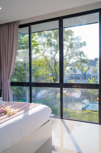 a bedroom with a large window and a bed at Snap stay pool villa pattaya พัทยา บ้านพักพัทยา พูลวิลล่าพัทยา in Ban Huai Yai