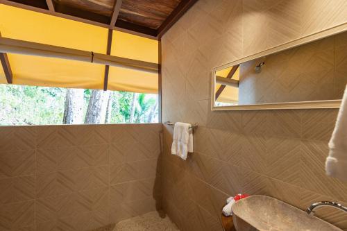 a bathroom with a sink and a mirror at Los Vivos Beachfront Experience in Pochote