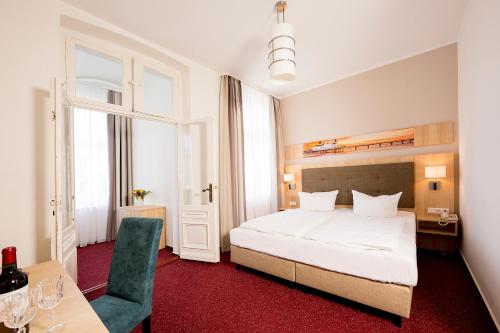 a bedroom with a bed and a table and a chair at Garni Eden Hotels in Ahlbeck