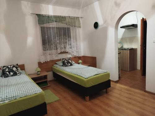sypialnia z 2 łóżkami i oknem w obiekcie Jaskółka w mieście Lądek-Zdrój