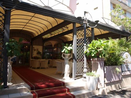 a pavilion with tables and potted plants in a building at Hotel Vienna Ostenda e Ristorante il Danubio in Rimini