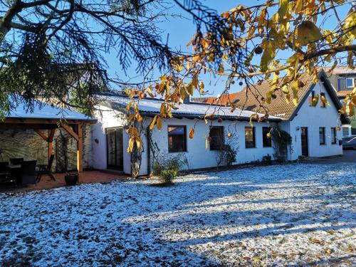 ein weißes Haus mit Schnee auf dem Boden in der Unterkunft Ferienhaus Marie in Wernigerode