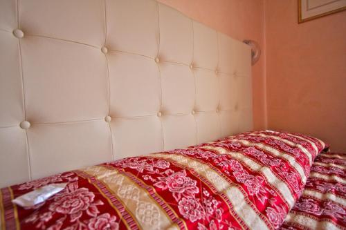 a white bed with a red blanket on it at Hotel Vienna Ostenda e Ristorante il Danubio in Rimini