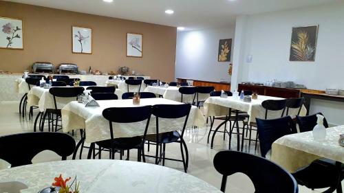 ein Zimmer mit Tischen und Stühlen mit weißem Tischtuch in der Unterkunft Hotel Bellavista in Paulo Afonso