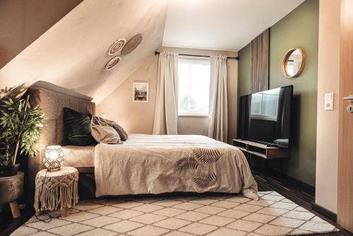 een slaapkamer met een bed, een raam en een televisie bij Feels like home in Ralingen
