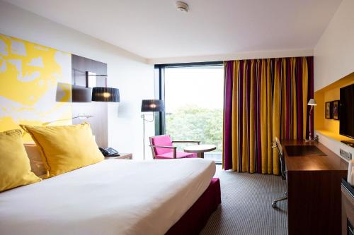 a hotel room with a large bed and a window at Radisson Blu Hotel, Montpellier in Montpellier