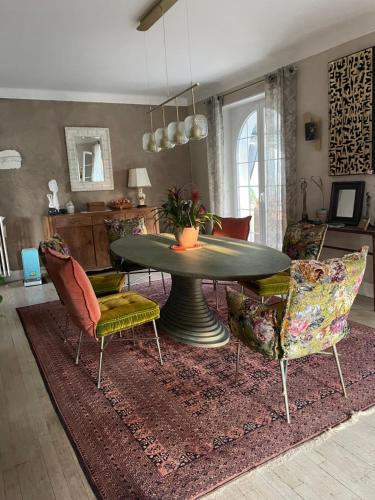 a living room with a table and chairs on a rug at Au temps suspendu in Champagney