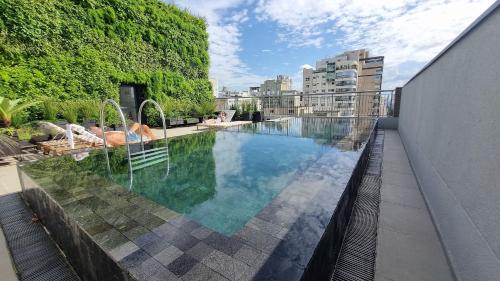 a swimming pool on the roof of a building at Canal do Anfitrião | Studios Jauperi in Sao Paulo