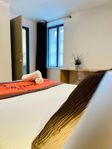 a bedroom with a bed with a towel on it at Au Coeur Des Bulles in Loches-sur-Ource