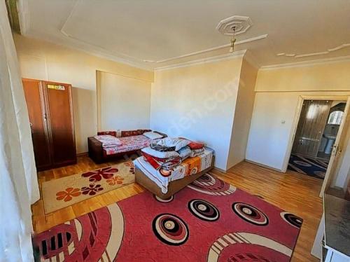 a room with two beds and a red rug at Suit home and room in city center in Erzurum