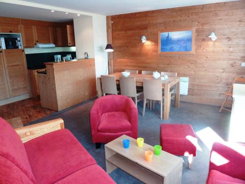 Il comprend un salon avec des chaises rouges et une table ainsi qu'une cuisine. dans l'établissement Appartement confortable pour 8 pers., proche remontées mécaniques, 3 chambres, 3 balcons - FR-1-634-2, à Morzine