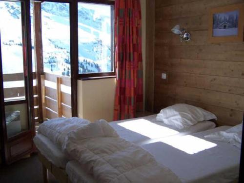 une chambre avec un lit et une grande fenêtre dans l'établissement Appartement confortable pour 8 pers., proche remontées mécaniques, 3 chambres, 3 balcons - FR-1-634-2, à Morzine
