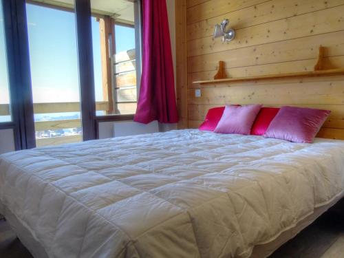 Un dormitorio con una cama grande con almohadas rosas. en Appartement 3 pièces pour 6/7 pers avec 2 salles de bains, buanderie, casier à skis et wifi - FR-1-634-11, en Morzine