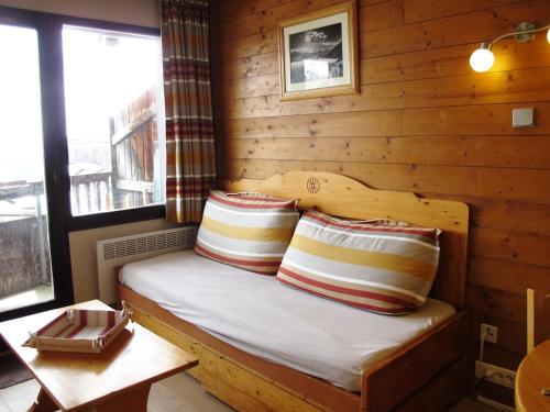 a bed in a log cabin with two pillows at Studio Avoriaz, 1 pièce, 4 personnes - FR-1-634-30 in Avoriaz