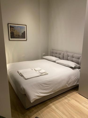 a bedroom with a large white bed with towels on it at #milanodabere Urban Loft in Milan