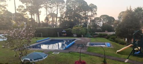 a backyard with a swimming pool and an umbrella at Alojamiento Cúpulas Avandaro in Valle de Bravo