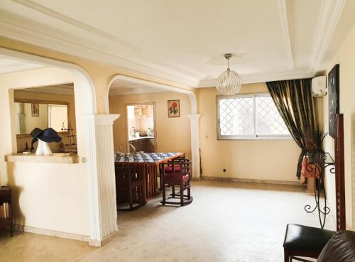 ein Wohnzimmer mit einem Tisch und einem Fenster in der Unterkunft Villa de charme avec jardin à Makepe in Douala