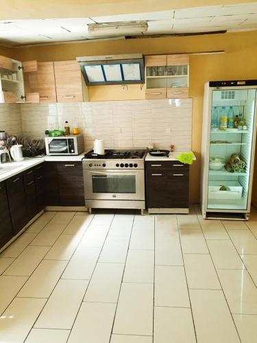 eine Küche mit einem Herd und einem offenen Kühlschrank in der Unterkunft Villa de charme avec jardin à Makepe in Douala