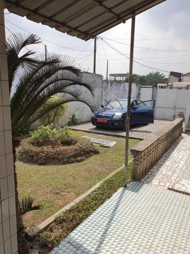 ein blaues Auto steht in einer Einfahrt in der Unterkunft Villa de charme avec jardin à Makepe in Douala