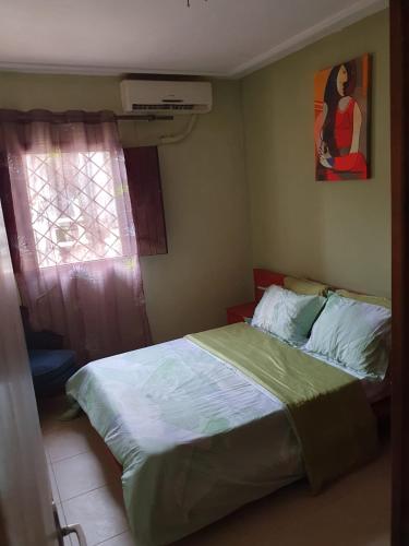 a bedroom with a bed and a window at Villa de charme avec jardin à Makepe in Douala