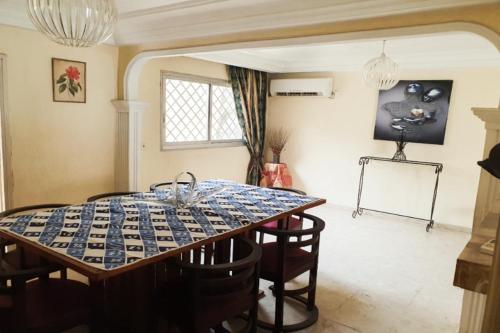 ein Esszimmer mit einem Tisch und Stühlen in der Unterkunft Villa de charme avec jardin à Makepe in Douala