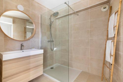 ein Bad mit einer Dusche, einem Waschbecken und einem Spiegel in der Unterkunft Balkoia superbe appartement de 75 m2 entièrement rénové in Saint-Jean-de-Luz